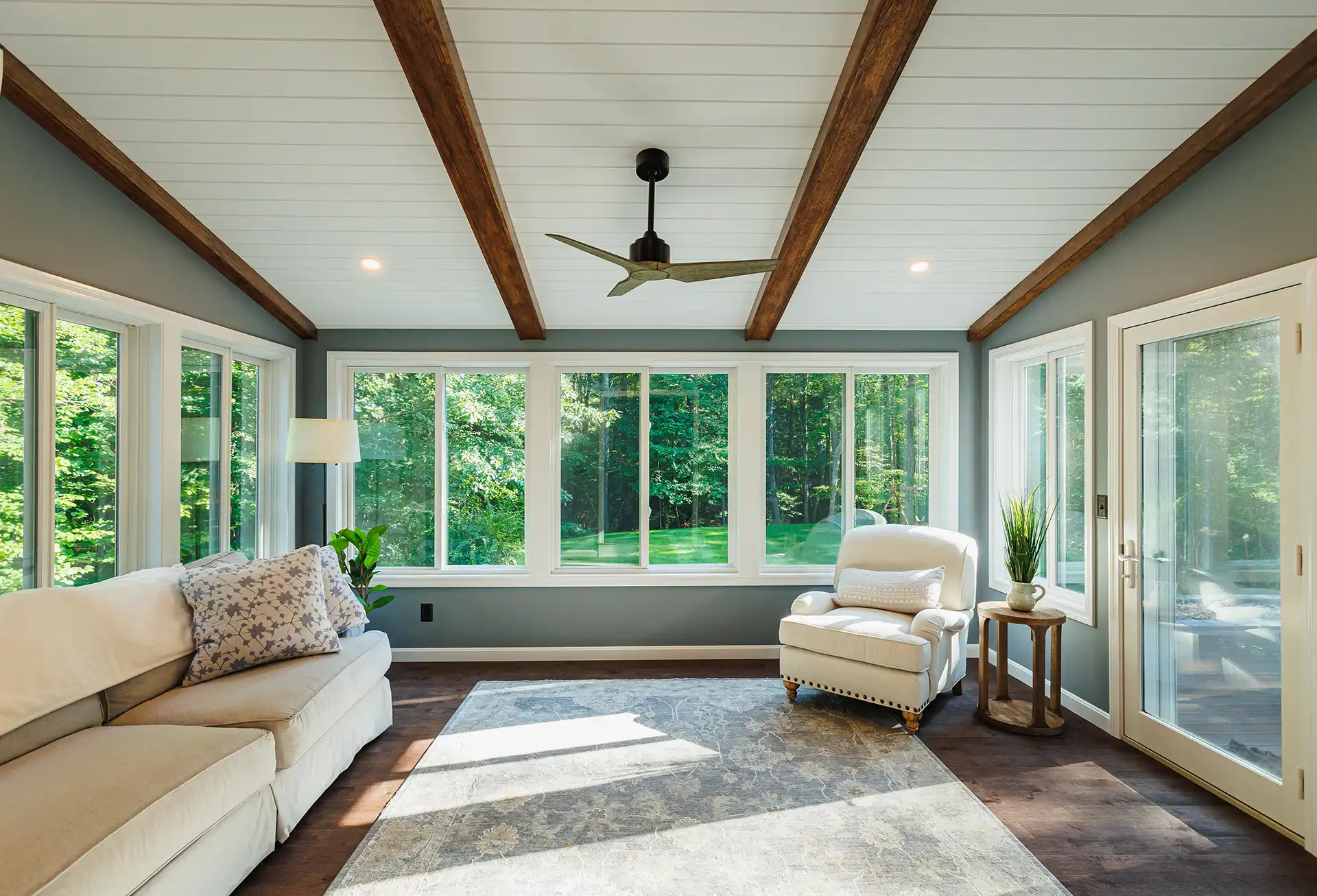 Photo of a four-season room with furniture, windows, and a ceiling fan - Sunroom builder and enclosures contractor - Southern, New Hampshire