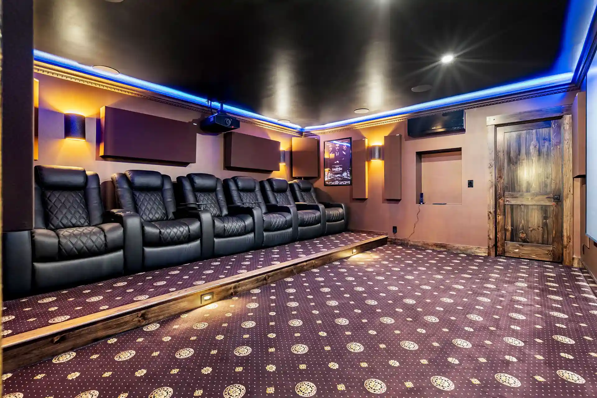 Photo of a home theater with reclining chairs in a finished basement.