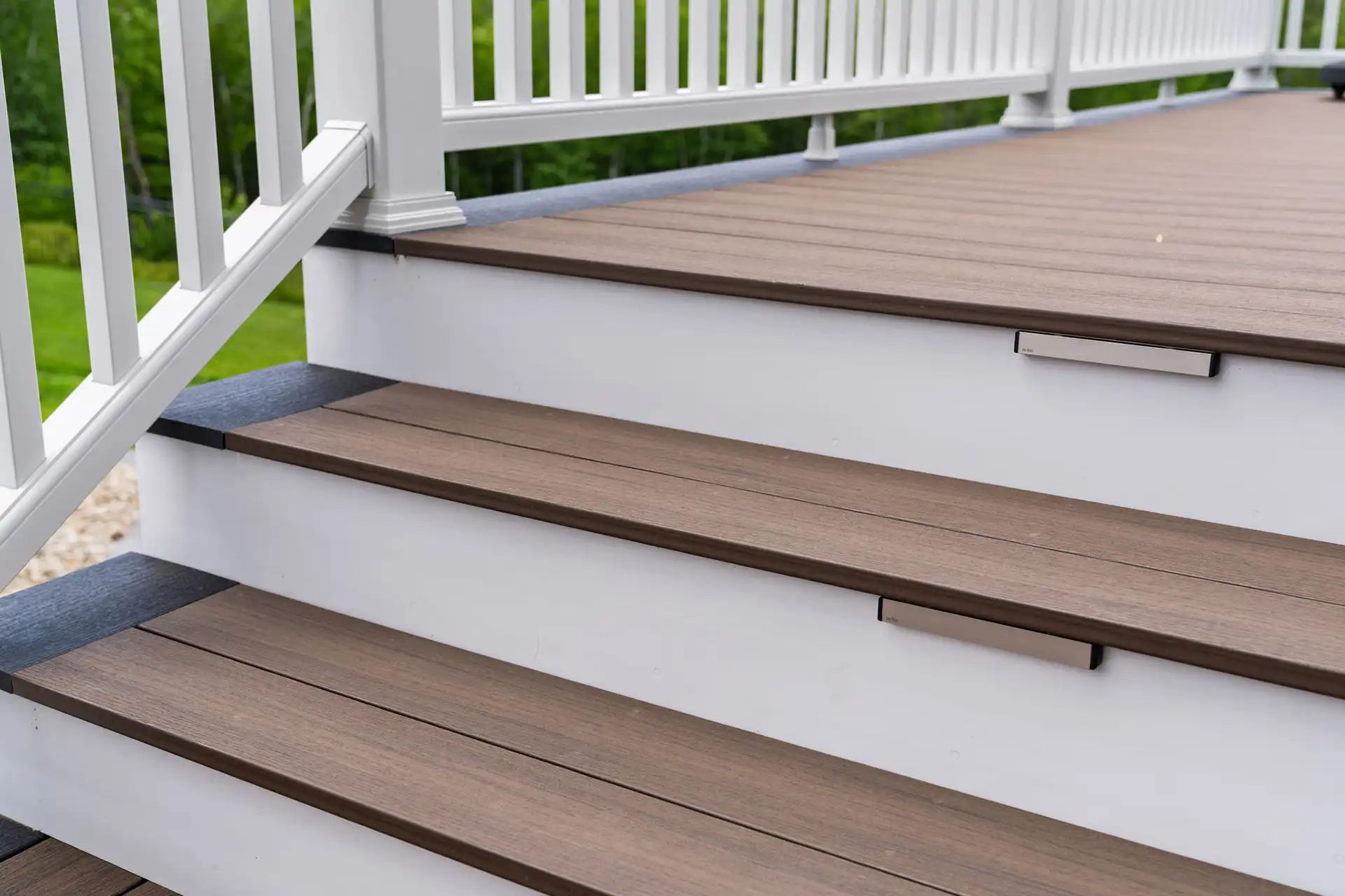 Photo of composite decking, deck steps with in-step lighting, and deck railing - Deck Builders and Outdoor Living Contractors in Southern New Hampshire