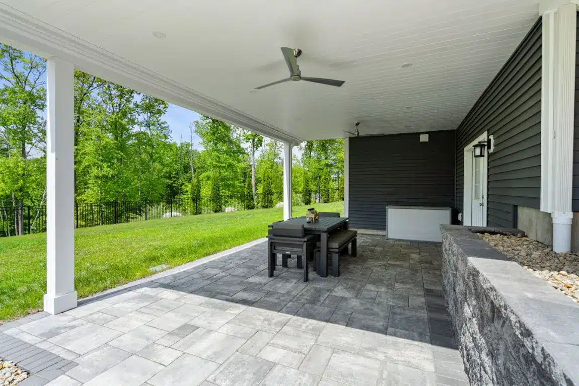 patio under an elevated deck with a retaining wall