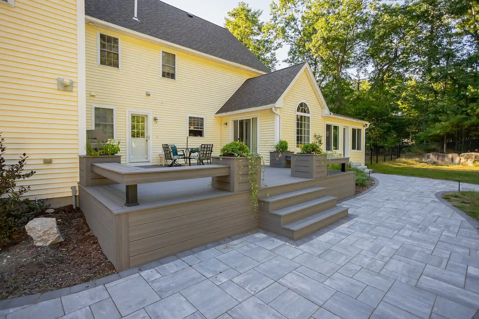 photo of a composite deck with paver walkway, flower boxes and built-in benches
